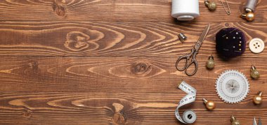 Ahşap zemin üzerinde Noel topları olan terzi malzemeleri ve metin için yer.