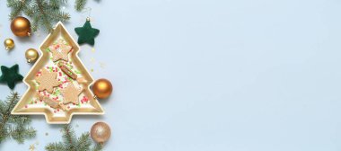 Noel ağacı şeklindeki tabakta kurabiyeler, şekerler ve ışık arkaplanı üzerindeki dekorasyonlar ve metin için yer var