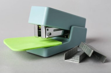 Gri arka planda yapışkan notları ve zımbaları olan ofis zımbası.