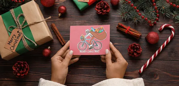 女性のカードを保持するテキストメリークリスマス木製の背景に トップビュー — ストック写真