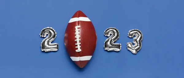 图2023蓝色背景的气球和橄榄球球 — 图库照片