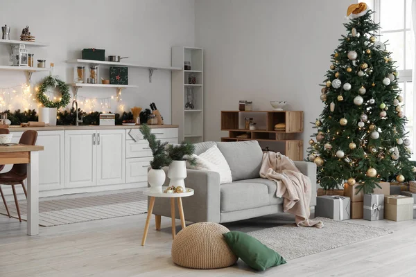 Interior of kitchen with sofa, Christmas tree and glowing lights