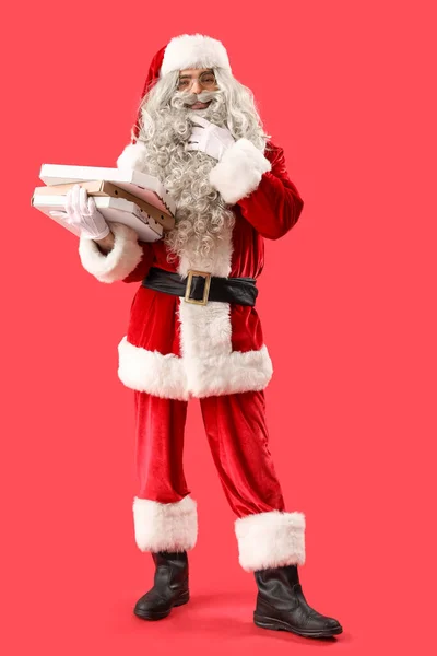Przemyślane Santa Claus Trzymając Pudełka Smaczną Pizzą Czerwonym Tle — Zdjęcie stockowe