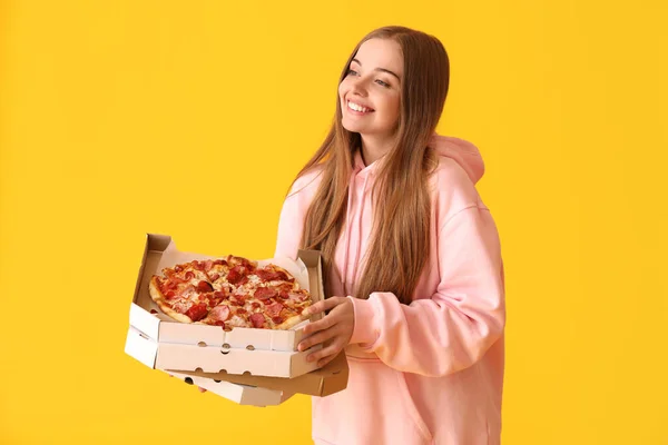 漂亮的年轻女子拿着盒子和黄色背景的新鲜披萨 — 图库照片