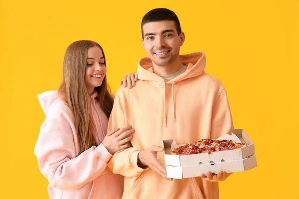 Glada Unga Par Med Färsk Pizza Gul Bakgrund — Stockfoto