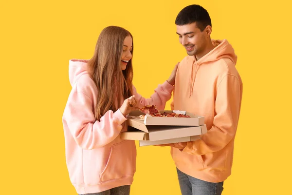 Glada Unga Par Med Färsk Pizza Gul Bakgrund — Stockfoto