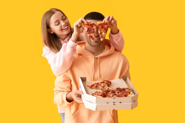 Zabawna Młoda Para Świeżą Pizzą Żółtym Tle — Zdjęcie stockowe
