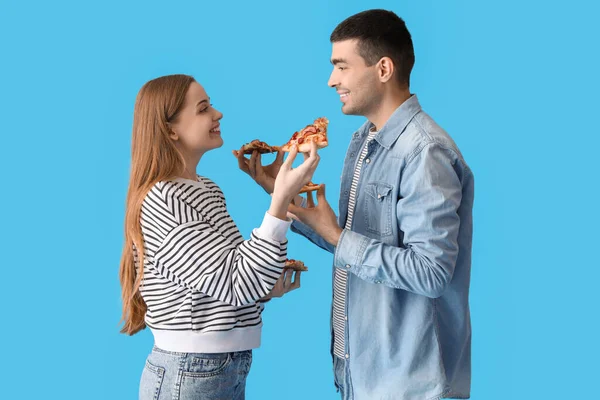 Glada Unga Par Äter Färsk Pizza Blå Bakgrund — Stockfoto