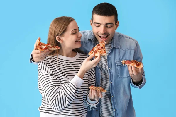 Szczęśliwa Młoda Para Świeżą Pizzę Niebieskim Tle — Zdjęcie stockowe