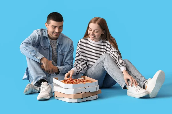 Szczęśliwa Młoda Para Świeżą Pizzę Niebieskim Tle — Zdjęcie stockowe