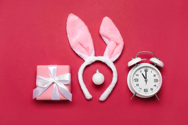 兔子耳朵 红色背景的圣诞球 礼物和闹钟 — 图库照片