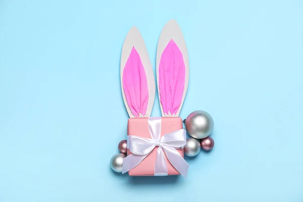 纸兔耳朵 圣诞球和蓝色背景的礼物 — 图库照片