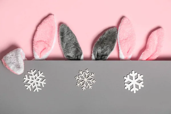 Konijnenoren Met Sneeuwvlokken Roze Grijze Achtergrond — Stockfoto