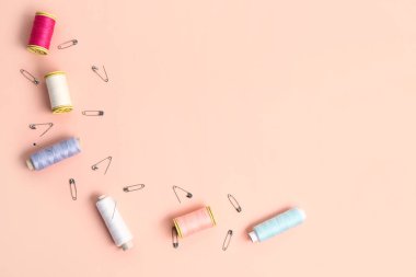 İplik makaralı kompozisyon ve pembe arka planda çengelli iğne