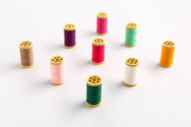 Işık arkaplanındaki birçok farklı iplik makarası