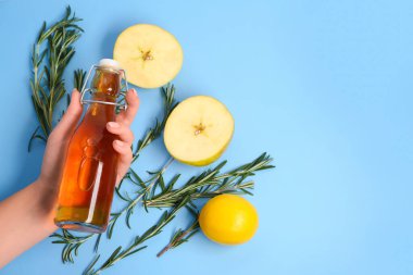 Arka planda taze elma suyu, meyve ve biberiye olan kadın eli.