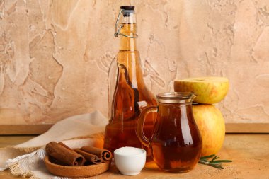 Masada bir şişe taze elma suyu, şeker ve tarçın.