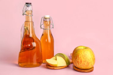 Pembe arka planda taze elma suyu ve meyveler