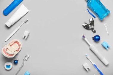 Gri arka planda Noel topları olan dişçi malzemelerinden yapılmış çerçeve