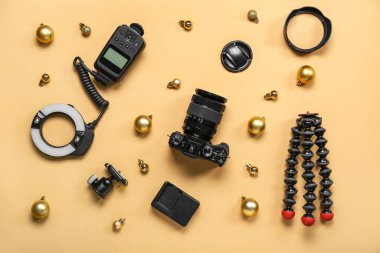 Bej arka planda Noel topları olan fotoğrafçı ekipmanları.