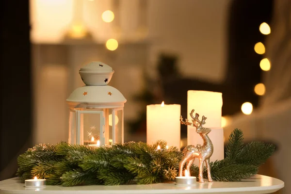 Рождественский Фонарь Горящими Свечами Еловыми Ветвями Оленями Столе Темной Комнате — стоковое фото