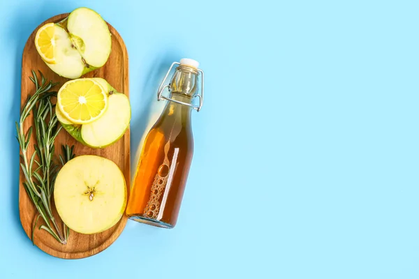 木の板にりんご レモンスライス ローズマリーとジュースのボトルの色の背景 — ストック写真