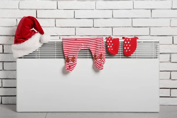 Elektrischer Heizkörper Mit Nikolausmütze Babybody Und Socken Der Nähe Weißer — Stockfoto