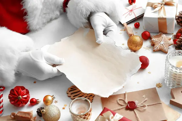 Święty Mikołaj Trzyma Pustą Literę Białym Stole Wystrojem Świątecznym Zbliżenie — Zdjęcie stockowe