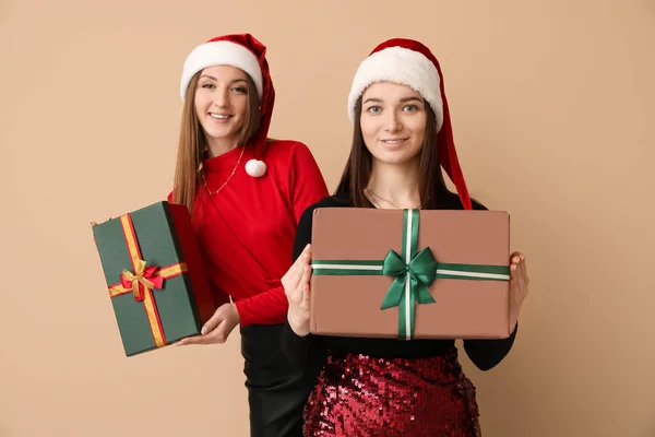 Молоді Жінки Капелюхах Різдвяними Подарунками Бежевому Фоні — стокове фото