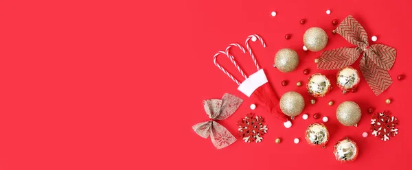 Kırmızı Zemin Üzerinde Noel Süsleri Baston Şekerler Noel Baba Şapkası — Stok fotoğraf