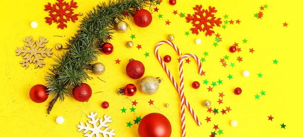 Skladba Vánoční Ozdobou Cukrovou Třtinou Jehličnatou Větví Žlutém Pozadí — Stock fotografie
