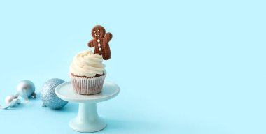 Zencefilli kurabiye ve açık mavi arka planda dekorlu lezzetli bir Noel keki.