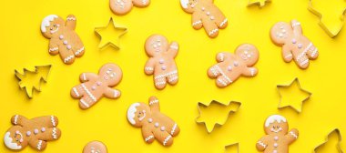 Sarı arka planda bir sürü zencefilli kurabiye ve keski var.