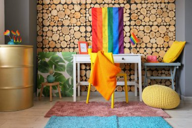 Ahşap duvarın yanında gökkuşağı bayrakları olan şık bir iş yeri.