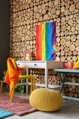 Ahşap duvarın yanında gökkuşağı bayrakları olan şık bir iş yeri.