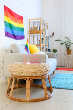 Rahat kanepe, puf ve gökkuşağı bayrakları odada.