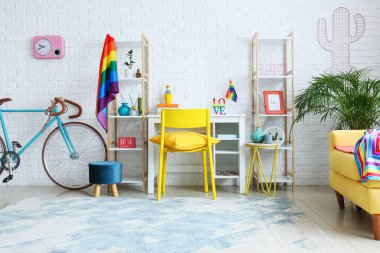 Beyaz tuğla duvarın yanında bisiklet ve gökkuşağı bayraklı işyeri