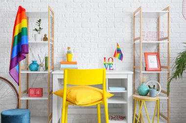 Beyaz tuğla duvarın yanında gökkuşağı bayrakları olan şık bir iş yeri