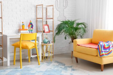 Rahat bir kanepe ve gökkuşağı bayraklı şık bir iş yeri.