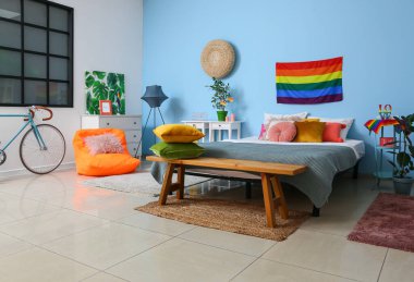 Gökkuşağı bayraklı ve ahşap banklı modern yatak odasının içi