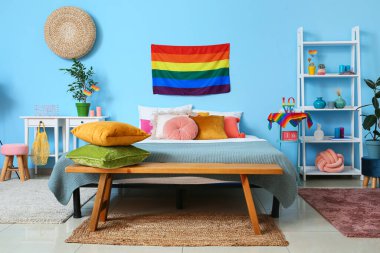 Gökkuşağı bayraklı ve ahşap banklı modern yatak odasının içi