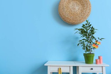 Gökkuşağı bayrakları ve mavi duvarın yanındaki masada mumları olan güzel bir çiçek.