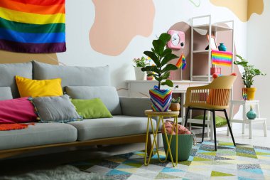 Rahat kanepe, şık iş yeri, ev bitkileri ve gökkuşağı bayrakları