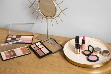 Dekoratif makyaj sehpası ve ışık duvarının yanındaki ahşap masada ayna.