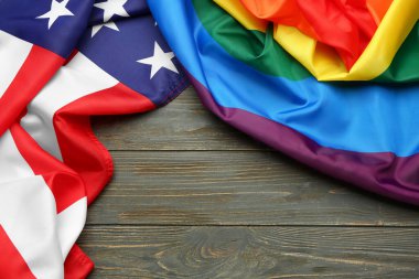 Koyu ahşap arka planda LGBT ve ABD bayrakları