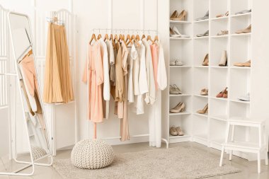 Rafları, giysileri ve rafları olan hafif soyunma odasının içinde.