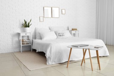 Boş çerçeve ve masalarla aydınlık yatak odasının içi