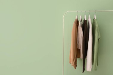 Yeşil duvarın yanında şık elbiselerle dizilin.