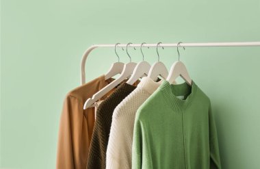 Yeşil duvarın yanında şık elbiselerle dizilin.