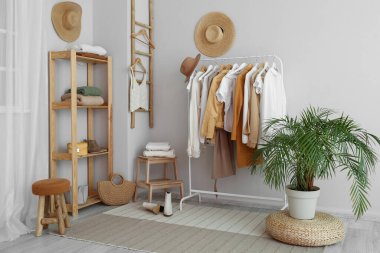 Rafları, giysileri ve rafları olan hafif soyunma odasının içinde.